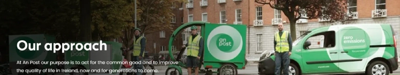 A man and a woman standing in front of An Post vans