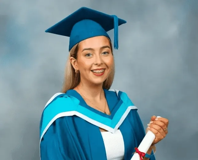 Photo of Roisin holding her college degree