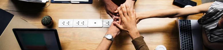 Team putting hands in together in a meeting