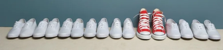 White shoes in a line with red converse amongst them