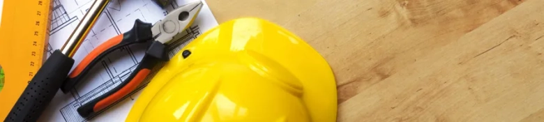 A yellow hard hat on a wooden table