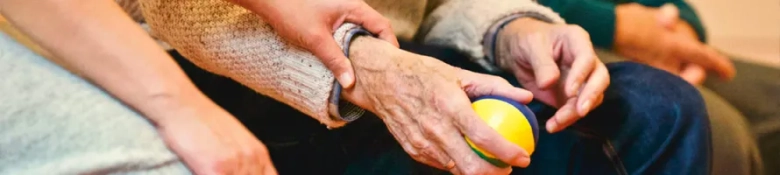 Carer holds elderly persons hand