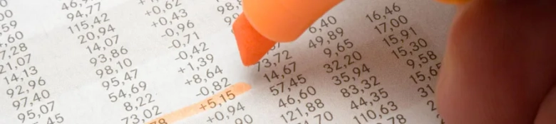 Close-up of a financial report with numbers highlighted by an orange marker.