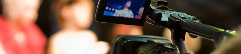 Close-up of a digital camera recording a blurred performer on stage, capturing live performing arts.