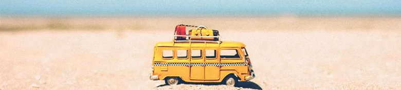 Toy minivan on a beach in front of the sea