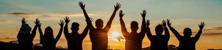 Image of people together with their hands in the air