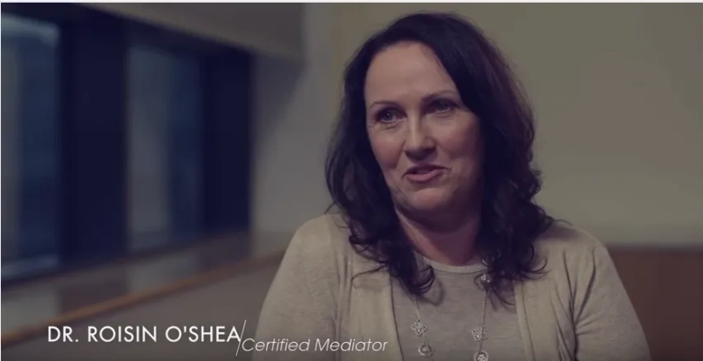 Dr. Roisin O'Shea smiling during an interview, with a caption identifying her as a Certified Mediator.