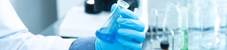 Image of scientist with blue glove and test tubes