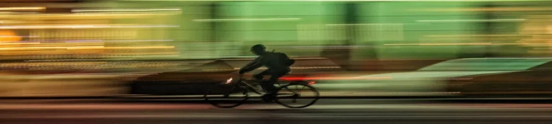 Blurred motion image of a delivery cyclist at speed, symbolizing the fast-paced nature of gig economy work.